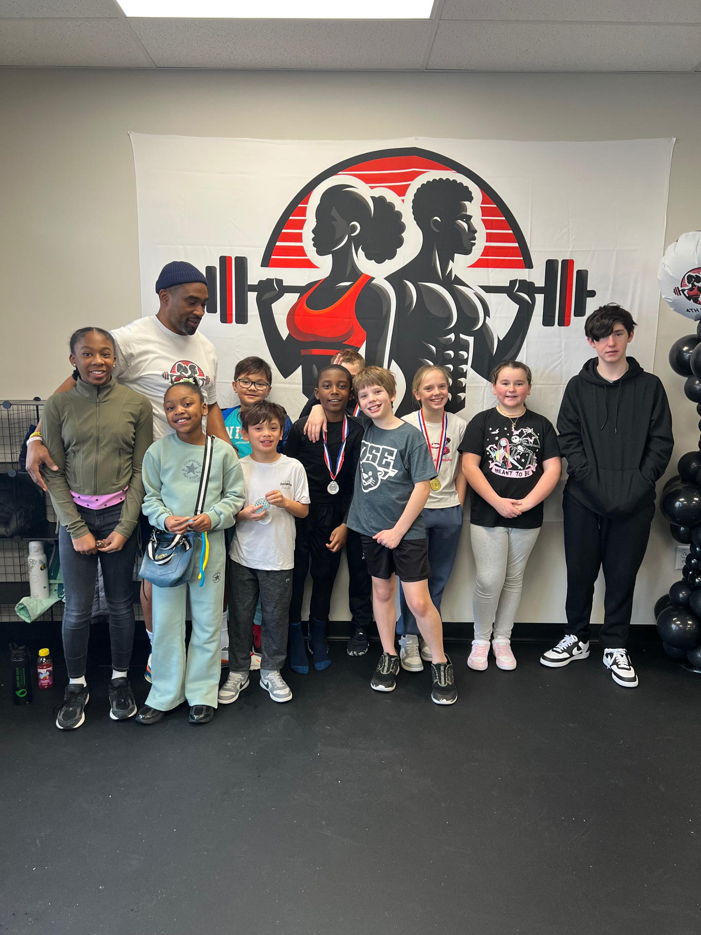 Coach C with youth program kids and medals